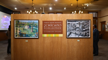 a group of people looking at pictures on display in a museum