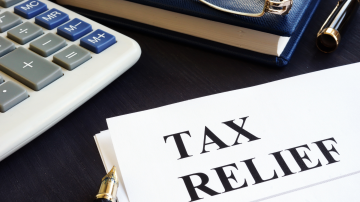 Tax relief concept. Calculator, note pad and pen.