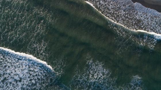 Aerial view of waves crashing against the coastline