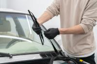 Man replacing a windshield wiper.