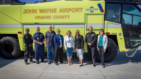 Members from the Orange County Fire Authority, John Wayne Airport, and Orange County Supervisor Katrina Foley stand in front of a new Crash 3 vehicle at Orange County Fire Station 33.
