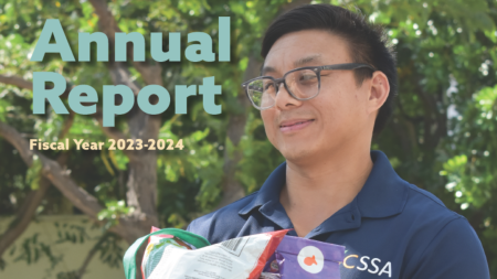 A person holding a book with the words annual report