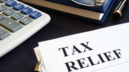 Tax relief concept. Calculator, note pad and pen.