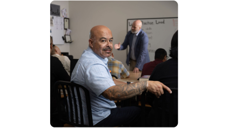 Image of individual who was justice involved inside a classroom, linked to an external page "OC Cares Justice, Prevention, and Intervention"