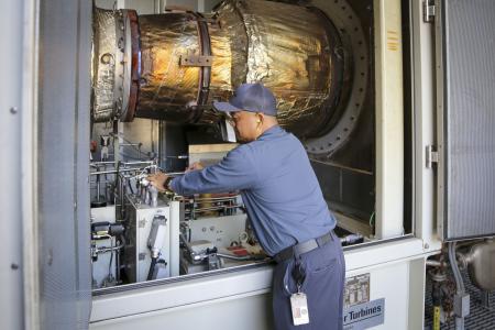 Maintenance worker checking an indoor turbine.