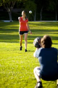 Two people passing a baseball in a field